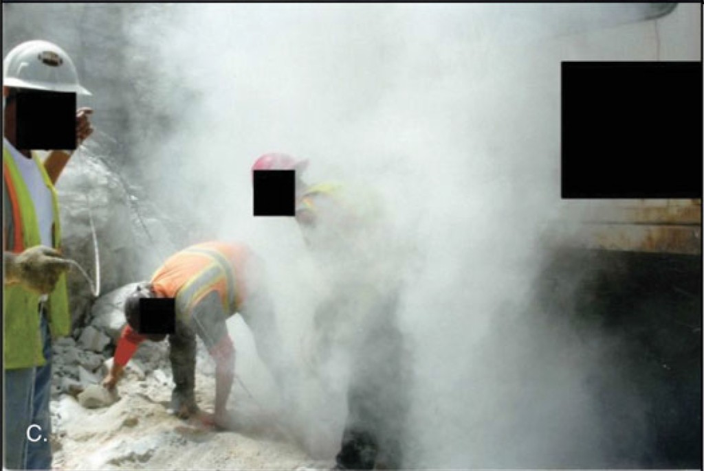 Taken in 2012 at a surface coal mine, it shows three miners enveloped in a dust cloud loading drill holes to blast overburden
